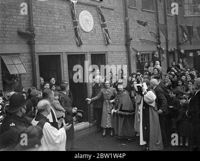 Duchess of Gloucester eröffnet neue Wohnungen im East End, die von der Church Army gebaut wurden. Nach der Eröffnung der neuen Wohnungen, die in der Prince Regent Lane, Custom House [ Newham ], für die Umsiedlung von Familien aus Slums und überfüllten Gebieten gebaut wurden, enthüllte die Herzogin von Gloucester eine Gedenktafel und spielte Tischtennis mit einigen der Bewohner. Foto zeigt: Die Herzogin von Gloucester enthüllt eine Tafel in den neuen Wohnungen. Mit ihr sind Prebendary Carlyle, Leiter der Kirchenarmee, und Frau Parsons, Bürgermeisterin von West Ham. April 1937 Stockfoto