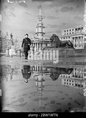 Die Duschen im April machen einen Trafalgar Square Spiegel. Die Kirche von St Martin in the Fields, das Südafrika Haus und einer der Trafalgar Square Lions spiegeln sich nach dem Regen in einem Wasserbecken. 16. April 1937 Stockfoto