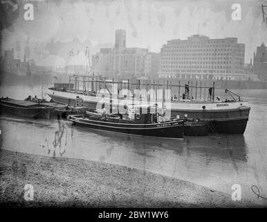 Rot-weiß und blau Krönungsbarge. Krönungsstand wird auf einem Lastkahn gemalt rot weiß und blau von Lambeth Bridge vertäut gebaut. Wenn der Stand fertig ist, wird der Barge nach Westminster geschleppt. Foto zeigt, den Stand auf dem Kahn an der Lambeth Brücke zu bauen. 14. April 1937 Stockfoto