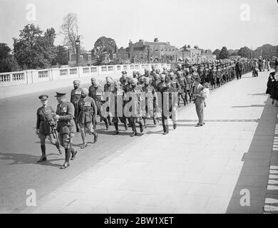 Das indische Krönungskontingent verlässt Hampton Court nach Hause. Mitglieder des indischen und burmesischen Krönungskontingent verließen ihr Lager am Hampton Court und verschlemmten nach Southampton, wo sie sich nach Neuralia aufmachen werden. Es gibt 600 Männer in dem Kontingent. Foto zeigt: Das Kontingent marschiert über die Hampton Court Bridge. 25 Mai 1937 Stockfoto