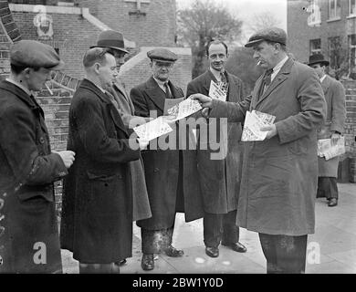 Busmen treffen sich in London, um Streikmaßnahmen zu unterstützen. In der Woodbury Hall, Green Lanes, Stoke Newington, fand eine Versammlung von Busdelegierten der Transport and General Workers Union statt, bei der erwartet wurde, dass die endgültige Zustimmung zu den Streikmaßnahmen nach dem vollständigen Scheitern der Verhandlungen, die die ganze Woche über geführt wurden, gegeben wird. Das Foto zeigt, wie die Busleute Flugblätter verteilten, die den Standpunkt der Busmänner während der Sitzung vorbringen. 30. April 1937 Stockfoto