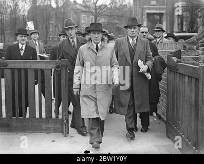 Busmen treffen sich in London, um Streikmaßnahmen zu unterstützen. Eine Versammlung von Busdelegierten der Transport and gen Workers Union fand in der Woodbury Hall Green Lanes, Stoke Newington, statt, als erwartet wurde, dass die endgültige Zustimmung zu den Streikmaßnahmen nach dem vollständigen Scheitern der Verhandlungen gegeben werden würde, die die ganze Woche über geführt wurden. Foto zeigt, Herr F Snelling, Vorsitzender des Zentralbuskomitees (Mitte, leichter Regenmantel) Ankunft mit heikel für das Treffen. 30. April 1937 Stockfoto