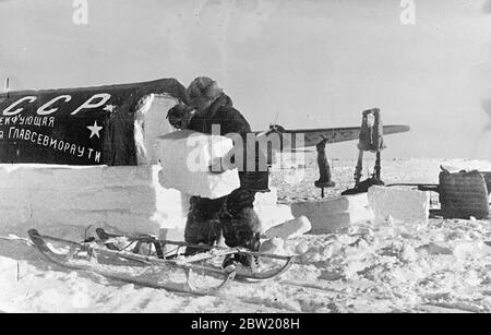 Diese Bilder vom Nordpol wurden nach Moskau und von dort nach London geflogen. Die sowjetische wissenschaftliche Expedition unter Leitung von Professor Otto Schmidt hat erfolgreich ein Wissenschaftsdorf auf einer Eisscholle in der gefrorenen Wildnis gegründet, aus dem nun erstmals in der Geschichte wertvolle wissenschaftliche Informationen und regelmäßige Wetterberichte per Funk gesendet werden. Ivan Papanin, der Führer der Partei, packte Eis um eines der Zelte der Station und verwandelte es in ein Eishaus. 30 Juni 1937 Stockfoto