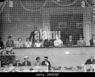 König und Königin und Prinzessinnen auf internationaler Pferdeshow. Der König und die Königin, mit Prinzessin Elisabeth und Prinzessin Margaret Rose, nahmen an der internationalen Pferdeshow in Olympia Teil, als ein besonderes Gala-Programm vorgestellt wurde. Das wichtigste Ereignis war der Offiziersspringen Wettbewerb für König George V Gold Challenge Trophy. Foto zeigt, der König und die Königin und die Prinzessinnen beobachten die Anzeige. Prinzessin Elizabeth beißt sich mit Aufregung in die Finger. 24 Juni 1937 Stockfoto