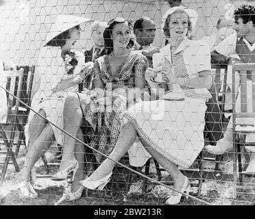 Das lustigste Tennisspiel der Welt wurde auf dem Platz des Beverly Hills Tennis Club, Beverly Hills, Kalifornien, zwischen Charlie Chaplin gespielt, in Zusammenarbeit mit Fred Perry und John Marks, die mit Ellsworth Vines spielten. Perry und Chaplin gewannen 6:1, 9:7. Foto zeigt: Frau Douglas Fairbanks (früher Lady Ashley); Paulette Goddard, Chaplins Hauptdarstellerin; und Helen Vinson, Frau von Fred Perry, die das Spiel beobachtet. Hintere Reihe, von links nach rechts: SID Grauman; Douglas Fairbanks und Gilbert Roland. 19 Juli 1937 Stockfoto