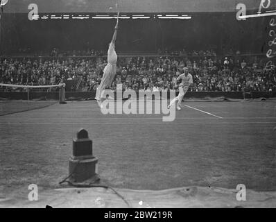 Donald Budge springt beim Spiel gegen Gene und Mako, die Amerikaner, die Wimbledon Doppel-Champions sind, um den Ball zu spielen, nahm die ersten beiden Sätze 6:3; 7-5 von CRD Tuckey und SH Wilde im Doppel der Davis Cup Challenge Runde in Wimbledon. 26 Juli 1937 Stockfoto