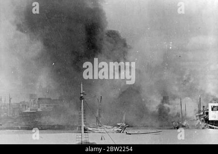 Die Wolken des schwarzen Rauchs, die aus den großen Feuern aufstiegen, begannen in Pootung, Shanghai [Pudong] durch japanische Bombardements. Pootung liegt am Ufer des Whangpoo Flusses [Huangpu Fluss] gegenüber der Hauptstadt in den chinesischen Stellungen, die dort unerbittlich von japanischen Flugzeugen bombardiert worden waren. 21. September 1937 Stockfoto