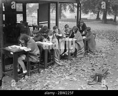 Es liegt ein Nip in der Luft. Die Schulkinder des St James's Park nehmen sich die Decken. Der Herbst hat kühle Winde nach London gebracht, und die Schüler der Open-Air-Schule im St James's Park haben Zuflucht in Decken gesucht, um sich beim Unterricht warm zu halten. Fotoausstellungen, Schüler in Decken in der Freilichtschule St. James's Park. 21. September 1937 Stockfoto