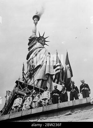 Die Fackel der Freiheit brennt, als die Amerikaner an den 150. Jahrestag der Verfassung erinnern. Der hundertfünfhundertfünfhundertste Jahrestag der Unterzeichnung der Verfassung der Vereinigten Staaten von Amerika wurde auf Liberty Island, am Fuße der Freiheitsstatue im New Yorker Hafen, gefeiert. Die Feierlichkeiten dauerten eine Woche. Foto zeigt, eine Ehrenwache der amerikanischen Armee, Marine und Luftwaffe stehen zur Aufmerksamkeit als Rauch aus der Fackel der Freiheitsstatue gegossen, die die Eröffnung der Feierlichkeiten signalisieren. 20. September 1937 Stockfoto