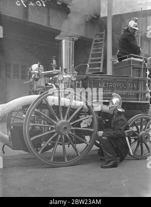 Alte und neue Methoden der Brandbekämpfung demonstrierte die Londoner Feuerwehr in einer Vorzeige vor dem Feuerwehrchef aus allen Teilen Englands im Brigadehauptsitz in London. Für die Anzeige wurden Feuergeräte vergangener Jahrhunderte und die aktuellste Ausrüstung verwendet. Feuerwehrleute bereiten eine alte Dampffeuerwerke für die Anzeige vor. 13. Oktober 1937. Stockfoto