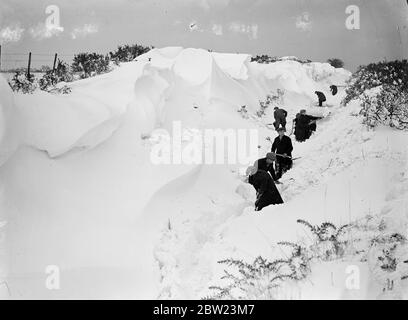 Schneesturm Haufen driftet 8 Fuß tief auf Kent Downs, Dörfer isoliert. Blizzard, der viele Stunden wütete, hat viele Meter tief dahindriftet und mehrere Kent-Dörfer mit Isolation bedroht. In einigen Fällen wurden Schneepflüge verwendet, um blockierte Straßen zu löschen. Zwischen Folkestone und Canterbury driftet auf den Höhen der Hecken auf den Downs mit Blick auf Folkestone, der Stil war 8 Meter tief. Foto zeigt, eine Bande von Männern graben aus der immensen driftet Kreta Straße auf den Downs mit Blick auf Folkestone. 16 Februar 1938 Stockfoto