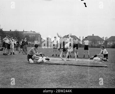 Eine neue Art von Krieg der Geschlechter ist in den körperlichen Trainingsplan der Barking Abbey School, Essex, wo Mädchen wie Jungen Unterricht in der Wissenschaft von Jujitsu nehmen und oft in gemischten Anstehen teilnehmen. Foto zeigt: Ein junger Amazon bringt einen effektiven Schulterwurf an der Barking Abbey School ab, während ein anderer einen effizienten Zehenverschluss anwendet. Oktober 1938 Stockfoto