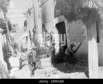 Die bisher kühnste Ausbeuten der arabischen Rebellen in Palästina war die Invasion von Bethlehem. Das Hauptobjekt des Angriffs war das Postamt in der Polizeistation, beide wurden während der Rebellenbesetzung der Stadt entschlackt. Die Polizeistation befand sich dort, wo Christus geboren wurde. Fotoausstellungen: Jugendliche Bürger von Bethlehem amüsieren sich, indem sie versuchen, die lokale Zerstörung, die die Polizeistation zu vervollständigen. Ein Junge benutzt ein Schild Diese Straße ist verboten als Verein. 19. September 1938 Stockfoto