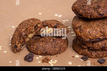 Haferflocken-Schokoladenkeksen gefüllt mit Apfel mit Haferflocken und Schokoladenspäne auf Papier Hintergrund. Stockfoto