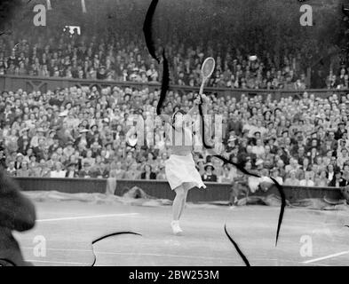 Helen Jacobs ruht nach der Etappe im Wimbledon-Finale. Miss Helen Jacobs musste sich ausruhen, nachdem ihr Bein im zweiten Satz ihres Spiels nachgab, als sie im Finale der Frauen-Singles in Wimbledon die Agaistin Mrs Helen W ills Moody war. Frau Moody gewann ihr 8. Finale mit 6:4, 6:0. Das war das vierte Mal, dass sie sich im Finsl getroffen hatten. Foto zeigt, Frau Helen Wills Moody greift nach einem High Shot. Juli 1938 Stockfoto