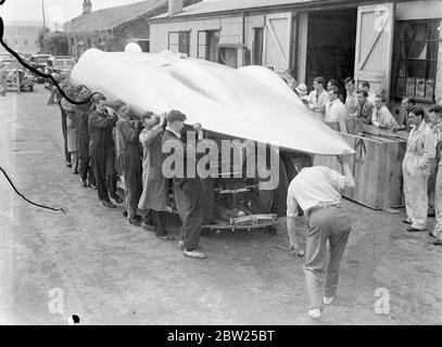 Cobbs neues Auto in Brooklands vor der Reise nach Amerika. Das Railton-Auto, in dem John Cobb Ende August in den Utah Salt Flats einen Versuch zum Weltrekord auf dem Land machen soll, war in seiner fertigen Form erstmals in Brooklands zu sehen, bevor es nach Amerika abging. Das Auto ist mit 1,250 PS Motoren ausgestattet. Cobbs Cockpit befindet sich vor der Achse in der Nase des Autos. Foto zeigt, dass die Karosserie auf dem Fahrgestell des Autos abgesenkt wird. Dieser leichte Körper muss angehoben werden, damit eine Einstellung vorgenommen werden kann. Juli 1938 Stockfoto