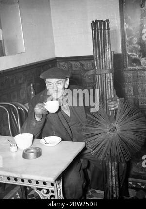 Ein Tag im Leben eines Schornsteinfegs. Ein Schornsteinfeger hat eine schnelle Tasse mit seinen Bürsten. Stockfoto