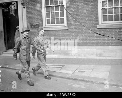 Army's experimentelle Kleidung in London zu sehen. Die experimentelle Gestaltung von Bekleidung für aktiven Dienst und Training, die in diesem Jahr Gegenstand von Versuchen der Armee sein soll, war im Central London Recruiting Depot, Great Scotland Yard, Whitehall zu sehen. Die Ausrüstung wurde mit dem Ziel entwickelt, das Gewicht des Soldaten so weit wie möglich zu verringern und die Mechanisierung und die neuen Waffen, die eingeführt wurden, zu berücksichtigen. Fotoausstellungen, Soldaten, die in den beiden experimentellen Uniformen laufen, Grundausstattung mit Webtaschen für Bren-Waffenmagazine, etc. (Links) und Stockfoto