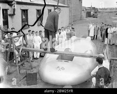 Cobbs neues Auto in Brooklands vor der Reise nach Amerika. Das Railton-Auto, in dem John Cobb Ende August in den Utah Salt Flats einen Versuch zum Weltrekord auf dem Land machen soll, war in seiner fertigen Form erstmals in Brooklands zu sehen, bevor es nach Amerika abging. Das Auto ist mit 1,250 PS Motoren ausgestattet. Cobbs Cockpit befindet sich vor der Achse in der Nase des Autos. Foto zeigt, John Cobb 'Walking the Plank', um das Cockpit des Autos. Dies ist der einzige Weg in das Auto.. Juli 1938 Stockfoto