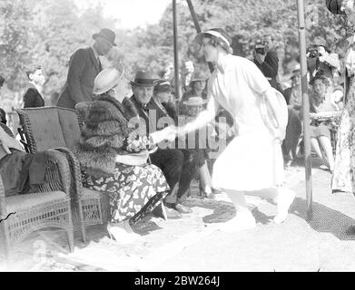 Queen Ena und helen Wills bei Highgate Tennis Party. Nur wenige Stunden nach dem Tod von Suzanne langlan besuchten Wimbledon-Spieler die jährlichen Lawn Tennis-Ausstellungspiele zu Hilfe des North islington Welfare Centre im Highgate (London), dem Heim von Sir Arthur und Lady Crosfield. Foto zeigt, Frau Helen Wills launisch, Wimbledon-Frau Champion, curtsieying zu Königin Ena von Spanien. Juli 1938 Stockfoto