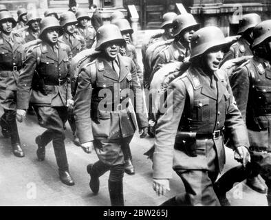 Österreichische Legion ist triumphierend nach Wien. Nach Jahren des Exils kehrten die ersten Abteilungen der Österreichischen Legion triumphierend in ihre Heimat zurück und marschierten mit Stahlhelmen und NS-Uniformen durch Wien. Die Legion besteht aus österreichischen Nazis, die vor der Annexion Österreichs durch Deutschland Zuflucht in Deutschland gesucht hatten. Foto zeigt, dass die österreichischen Legionäre singen, als sie bei ihrer Rückkehr durch Wien marschierten. 28 März 1938 Stockfoto
