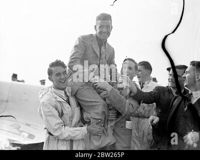 Henshaw erhält Trophäe von Air Minister nach dem Gewinn des King's Cup Race. Alex Henshaw, der in den ersten zehn Runden 236 Meilen pro Stunde zurückgelegt hatte, gewann das King's Cup Air Race in seinem Percival New Gul Flugzeug und erhielt die Trophäe von Sir Kingsley Wood, dem Air Minister. Die Strecke war über 1,000 Meilen, Start und Ziel in Hatfield. Foto zeigt, dass Alex Henshaw nach seinem Sieg den Vorsitz in Hatfield innehatte. Juli 1938 Stockfoto