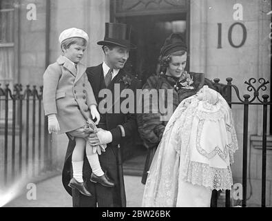 MPS Baby Tochter taufte im Haus der Commons Krypta. Die kleine Tochter von Somerset Maxwell, Abgeordneter der Kings Lynn Division von Norfolk, und Frau Maxwell wurde in der Kryptkapelle des Unterhauses getauft. Das Baby erhielt den ursprünglichen Namen Sheelin, nach einem lough in Irland, in der Nähe von Farnham, und Herr John Bingham, Sohn von Lord Lucan, waren die Babies Paten. Foto zeigt, Herr Somerset Maxwell, MP, und Frau Maxwell mit dem Baby, das ihr Londoner Zuhause zur Taufe verlässt. Mit ihnen ist ihr vierjähriger Sohn Simon. 24. Januar 1938 Stockfoto