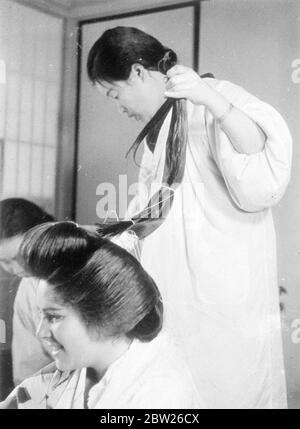 Japanische Mädchen einreichen, um 2 Stunden Agonie für verführerische coiffure. Nur wenige Menschen, die die schönen Frisuren japanischer Mädchen bewundern, erkennen die qualvolle körperliche Bestrafung, die sie durchmachen, um sie zu erhalten. Diese Bilder zeigen die komplizierten Prozesse, die nach zwei Stunden Arbeit auf Seiten des Kamiyuisan (Friseur) die endgültige Wirkung erzielen. Das Motiv für die Bilder, Adrienne Moore, und als die Frisur fertig war, sagte sie, dass sie sich beim Liegen in einem Stuhl fühlte, als ob Haskell erzählt würde und fand, dass es fast unmöglich sei, sich hinzulegen. Eine andere Tatsache, die sie entdeckte, war, dass J Stockfoto