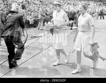 Helen Jacobs ruht nach der Etappe im Wimbledon-Finale. Miss Helen Jacobs musste sich ausruhen, nachdem ihr Bein im zweiten Satz ihres Spiels nachgab, als sie im Finale der Frauen-Singles in Wimbledon die Agaistin Mrs Helen W ills Moody war. Frau Moody gewann ihr 8. Finale mit 6:4, 6:0. Das war das vierte Mal, dass sie sich im Finsl getroffen hatten. Foto zeigt, dass Frau Helen Wills Moody und Frau Helen Jacobs nach ihrem Spiel vom Platz gehen. Juli 1938 Stockfoto