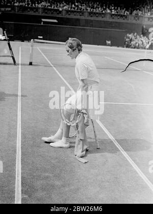 Helen Jacobs ruht nach der Etappe im Wimbledon-Finale. Miss Helen Jacobs musste sich ausruhen, nachdem ihr Bein im zweiten Satz ihres Spiels nachgab, als sie im Finale der Frauen-Singles in Wimbledon Frau Helen Wills Moody war. mrs Moody gewann ihr achtes Finale mit 6:4, 6:0. Foto zeigt, Helen Jacobs ruht auf ihrem Schläger, nachdem ihr Bein im zweiten Satz nachgegeben hatte. Juli 1938 Stockfoto