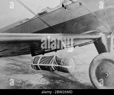 FALLSCHIRM DER US-Armee für das Abwerfen von Lieferungen an Truppen, die an den Bauch eines Flugzeugs mit unbekannter Beschreibung geheckt wurden. Stockfoto