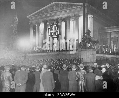 "Österreich bleibt frei!", betont Schuschniggs trotzige Rede Dr. Schuschnigg, der nach seinem Einvernehmen mit Hitler vor dem österreichischen Parlament sprach, dass die österreichische Unabhängigkeit erhalten bleiben würde. "Österreich wird frei bleiben", sagte er, "und für diesen Kampf. Wir werden bis zum Tod kämpfen. Heil Austria!'. Nach seiner Rede führte er eine jubelnde Menge von 4000 Anhängern durch Wien. Foto zeigt, wie die Menge vor dem beleuchteten Wiener Parlamentsgebäude zuhörte, während die Rede der Kanzlerin über Lautsprecher übertragen wurde. 25 Februar 26 1938 Stockfoto