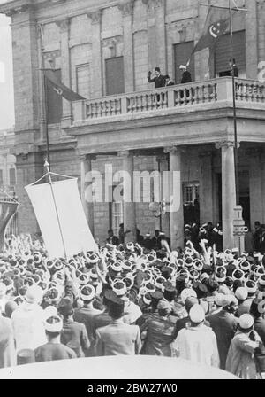 Die Hochzeit von König Farouk in Kairo. Mit traditioneller muslimischer Zeremonie wurde der 17-jährige König Farouk von Ägypten im Koubbeh-Palast in Kairo mit der Richterin des ägyptischen Berufungsgerichts, Frau Farida Zulficar Pasha, verheiratet. Foto zeigt, König Farouk winkt vom Balkon zum Abdin-Palast, Kairo, als Reaktion auf den Jubel der Beduinen, die aus der Wüste gekommen waren, um an den Hochzeitsfeiern teilzunehmen. 23. Januar 1938. Stockfoto