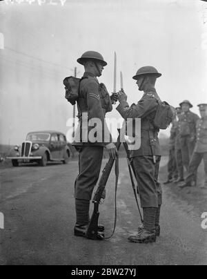 Das moderne 'Tommy' hat eine leichtere Last zu tragen! Die neueste Ausrüstung und Ausbildung der Infanterieeinheiten der britischen Armee wurde vom 1. Battlalion, dem South Staffordshire Regiment, in einer Reihe von Übungen im Aldershot Camp, Hampshire, demonstriert. Foto zeigt, und die alte und neue Ausrüstung, zeigt kürzere Bajonette, neue Munitionstaschen und Wasserflaschen in der Haversack statt an der Seite hängen. Diese Veränderungen wurden vorgenommen, um die Soldaten zu entlasten. 21. Januar 1938 Stockfoto