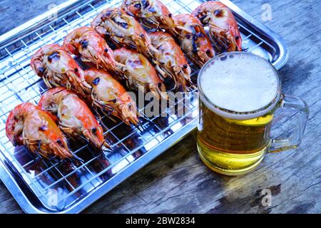 Gegrillte Garnelen (Riesenfresswater River Garnelen) Grillen mit Holzkohle zu Hause, natürliches Licht am Abend. Bangkok, Thailand. Stockfoto