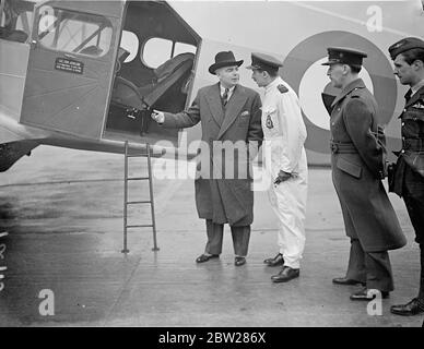 Hore Belisha verlässt das Hendon Aerodrome in die Ulster. Der Kriegsminister Leslie Hore Belisha verließ das Flugplatz der Royal Air Force Hendon zu einem Besuch der Inspektion im nordirischen Distrikt. Er wird während seines Aufenthalts Gast von Lord and Lady Londonderry in Monntstewart sein. Aber die Shows, Herr Leslie Hore Belisha im Gespräch mit Squadron Leader Goode (in weiß) am Hendon Aerodrome. 12. Januar 1938 Stockfoto