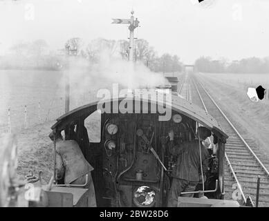 Die britischen Eisenbahnen überwinden die Nebeldrohung - hörbare Signale warnen den Fahrer und bremsen. Ein von Mitarbeitern des Eisenbahnpersonals erfundenes Gerät, das den Fahrern eine akustische Warnung gibt, wurde als Sicherheitshilfe auf dem Great Western Railway System in England installiert. Wenn die Linie frei ist, klingelt eine Glocke von der Fahrerseite, die ihm das Vorwegrecht gibt. Sollte das Signal auf 'Vorsicht' stehen, ertönt eine Sirene und die Bremsen werden automatisch im Zug betätigt. Und ich bin sicher, Sie unter der Lokomotive montiert verbindet mit der Rampe und gibt so das Signal an den Fahrer. Mit Hilfe dieses neuen sa Stockfoto