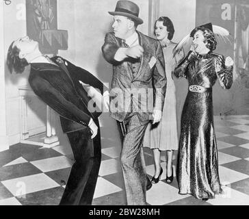 Reginald Gardner hat sich in Rehersal von Billie Burke und Lynne Carver anschaut. 20 Dezember 1937 Stockfoto