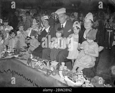 Bürgermeister von Southwark an Schulkindern bricht Partei. Die Kinder der Paragon School, New Kent Road, South London, hielten eine Zerbrechungsparty mit der Bürgermeisterin von Southwark, Ratsmitglied Frau Phyllis Tidy als Gast ab. Foto zeigt, dass die Bürgermeisterin von Southwark, Frau Phyllis Tidy, Herr Ellsmore, Bereichsleiter, und Frau Hilda Booth, die Direktorin, sich mit den Kindern auf der Party zum Tee setzen. 22 Dezember 1937 Stockfoto