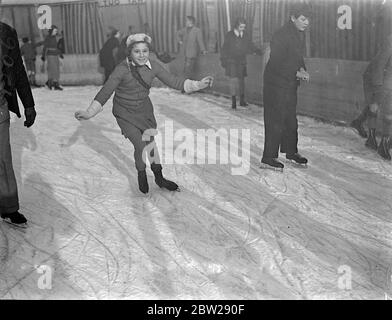 Zöpfe auf dem Eis von Wembley. Kindertag auf der Alpinbahn in Wembley. Die frische Luft machte die Bedingungen ideal für junge Skater, die am Kindertag über die alpine Freiluftbahn in Wembley glitt. Fotoausstellungen, Zöpfe und warme Strümpfe, die von kleinen Mädchen auf der Alpenroute getragen werden. 18 Dezember 1937 Stockfoto