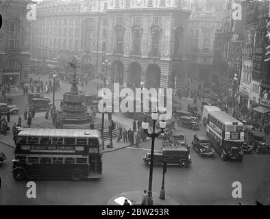 Neue Ampeln halten den Piccadilly-Verkehr in Bewegung. Ein Blick in Richtung Shaftesbury Avenue, der das reibungslose Verkehrsbetrieb um die Eros-Statue am Piccadilly Circus zeigt, nachdem die neuen automatischen, von Verkehrsminister Leslie Burgin angesteuerten Ampeln eingeschaltet wurden. 15. November 1937 Stockfoto