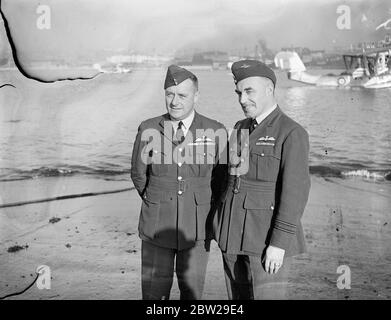 Der längste Formationsflug, den jemals von einer Service Unit unternommen wurde, sind fünf RAF-Flying Boats der Nummer 204 (Gen Reconnaissance) Squadron, die in Plymouth vorbereitet werden. Nächste Woche werden sie abheben und wenn ich im Frühjahr zurückkomme, wären sie 25,000 Meilen nach Australien und zurück geflogen. Der Besuch findet im Zusammenhang mit der 150-jährigen Feier von Sydney statt. Foto zeigt, Wing Commander Kenneth Lloyd AFC (links) , Kommandant der 204. Squadron, der die Formation mit dem Leiter der Geschwader VP Feather in Mountbatten, Plymouth, leiten wird. In der oberen rechten Ecke eine der Saunders Roe A Stockfoto