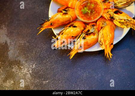 Gegrillte Garnelen (Riesenfresswater River Garnelen) Grillen mit Holzkohle zu Hause, natürliches Licht am Abend. Bangkok, Thailand. Stockfoto