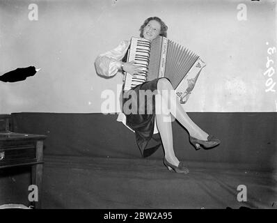 Der 'feminine Touch' bei den Akkordeon-Meisterschaften in London. Fast 1000 Akkordeonspieler, darunter Bands aus ganz Großbritannien, aber auch aus Deutschland, Kanada und China, nehmen an Meisterschaftswettbewerben in der Central Hall in Westminster Teil. Fotoausstellungen, Miss Lillian Vandenberg von der Norwich Akkordeonband, macht sich in der Central Hall ein wenig üben. November 1937 Stockfoto