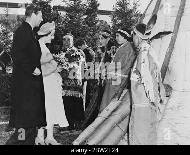 Originaltitel: Der königliche Besuch in Kanada. Der König und die Königin besuchten die Ojibway-Indianer [Ojibwe / Ojibwa / Chippewa / First Nations] bei der Siedlung, die sie am Ufer des McIntyre River im Port Arthur District von Ontario machten. Foto zeigt den König und die Königin im Gespräch mit Indianern, die für die Gelegenheit ihre modernen Kleider verworfen und Trachten und Federn trug. [Port Arthur, Fort William, Neebing bildete die Stadt Thunder Bay in den 1970er Jahren] 31. Mai 1939 Stockfoto