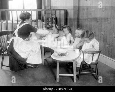 War Creche exklusiv für Munitionsarbeiter. Kinder in Acton, bekannt als die Acton Central Nursery. Die Ständer für die Wiegen werden von den Jungen in einer benachbarten Schule hergestellt. 12. Januar 1917 Stockfoto