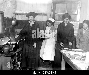 Lady Muriel Paget. Gesellschaft Damen helfen in der ungültigen Küche. Diese Küchen wurden gegründet, um den Invaliden und den Rekonvaleszenten Arbeitern täglich eine angemessene Ernährung zu bieten - jeder Empfänger muss für alle Mahlzeiten bezahlen, die berechnet werden, in einigen Fällen, die so niedrig wie ein Penny oder zwei Cent sind, entsprechend dem Lohn, der die verdiente Kapazität der bedienten Familie verdient. Lady Muriel Paget hilft beim Kochen. 28 Februar 1917 Stockfoto