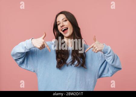 Bild von attraktiven jungen Frau mit langen braunen Haaren lächelnd und Zeigen Finger auf sich isoliert über rosa Hintergrund Stockfoto