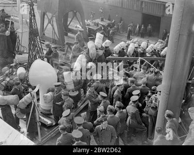 Das größte Kontingent von Offizieren und Männern der Royal Air Force, das jemals in einem Schiff im Rahmen des normalen Truppenprogramms nach Übersee geschickt wurde, ließ Southampton auf dem Truppenschiff Nevassa über verschiedene Einheiten im Irak, Indien, Aden, Khartum und Malta verstreut werden. Die Zahl der auf der Nevassa Reisenden Luftstreitkräfte beträgt etwa 1000, viele der Männer werden von den Familien begleitet, um die Truppenschaft voll zu ergänzen. Normalerweise werden die Transporte auch von der Armee und der Marine geteilt. Foto zeigt: Männer der Royal Air Force besteigen die Truppenschifffahrt mit ihren Kittbags. 25. Oktober 1938 Stockfoto