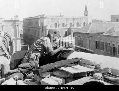 Als Ergebnis der entschlossenen militärischen Aktion der britischen Streitkräfte, die Rebellen in der Kontrolle der Altstadt von Jerusalem wurden verdrängt und britische Autorität wieder hergestellt. Der britische Angriff kam, nachdem die Araber die alte Stadt für eine Woche festgehalten hatten. 22 Araber wurden getötet und 25 verletzt. Dies war das erste Mal, dass moderne Kriegsausrüstung, einschließlich Flugzeuge, in einer Kampagne in der heiligen Stadt verwendet wurde. Foto zeigt: Der britische Soldat, der eine Lewis-Waffe auf einem der Dächer mit Blick auf die Moschee, Hochburg der arabischen Rebellen in der Altstadt, mannen lässt. 24. Oktober 1938 Stockfoto